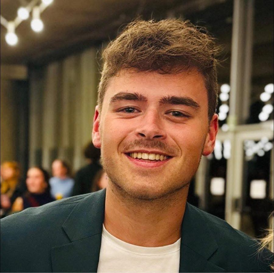 Portret van Joran, lachend, in een donkergroene blazer